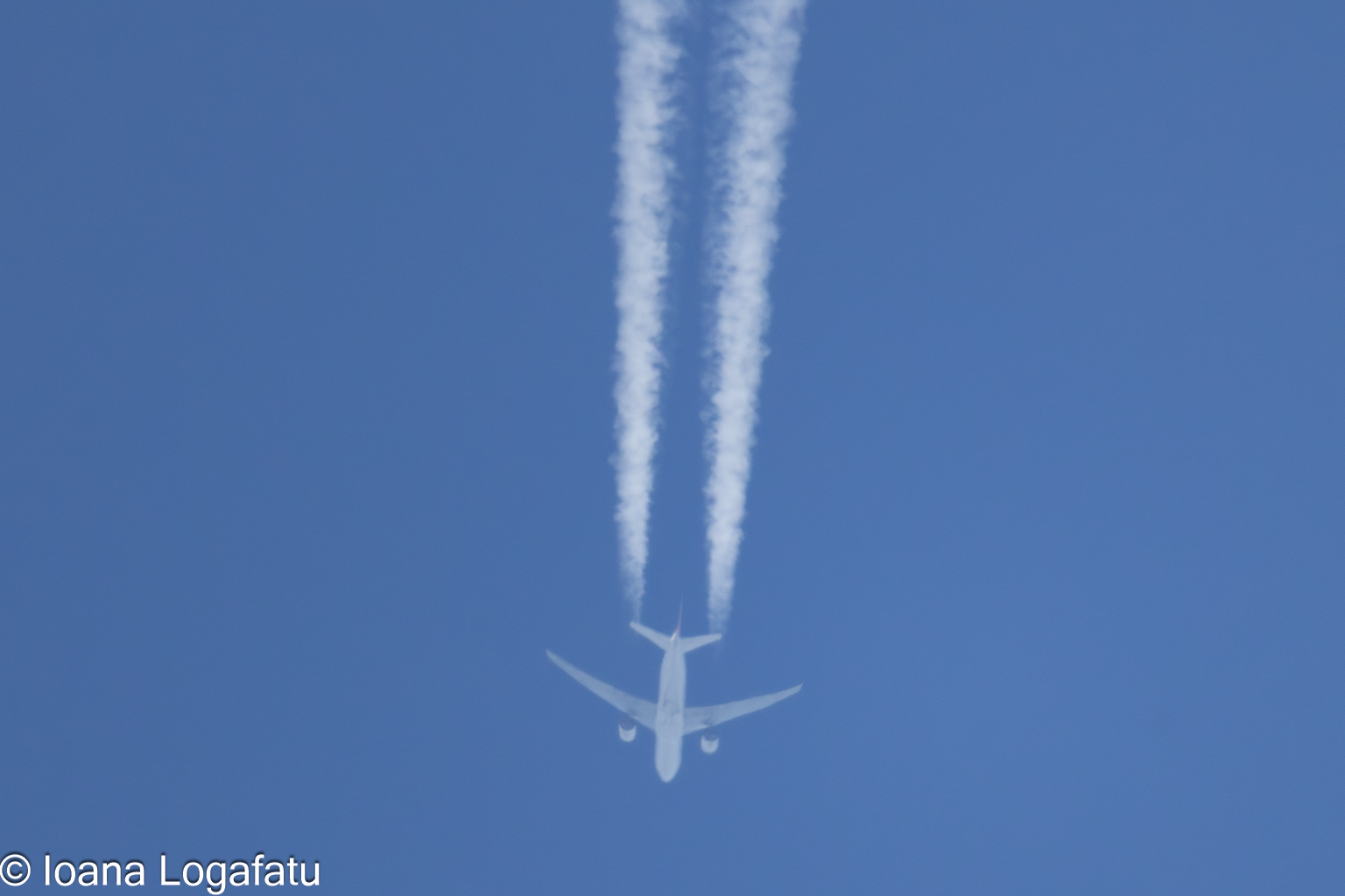 Jet soaring high in the clear blue sky above